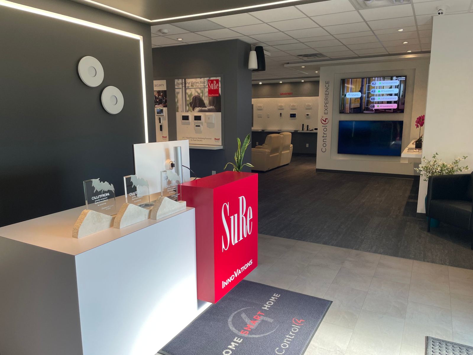 SuRe InnoVations Experience Center entrance with Lutron Diamond awards and the Control4 Experience wall